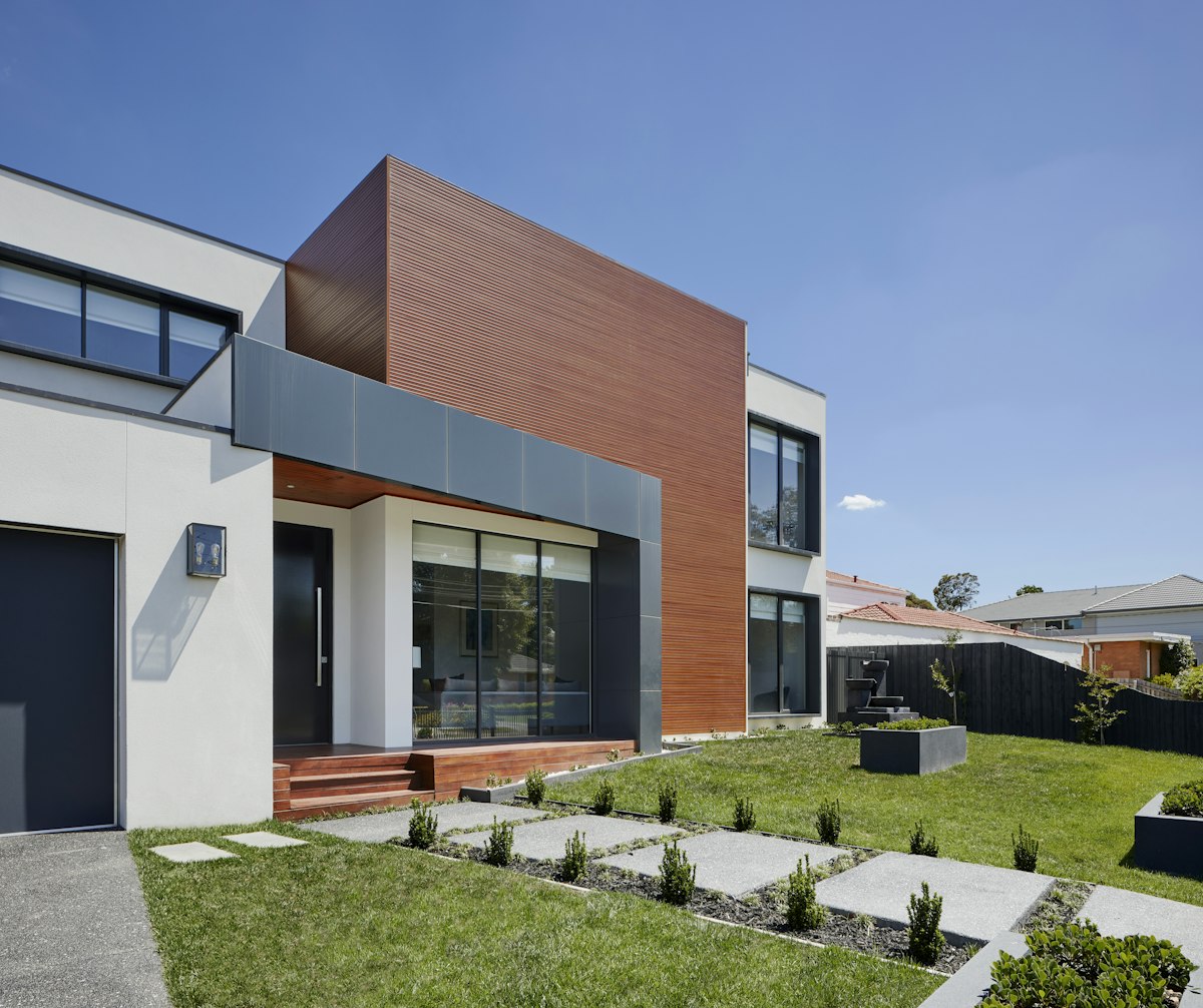 Angular contemporary house with dark cladding and large glazed openings