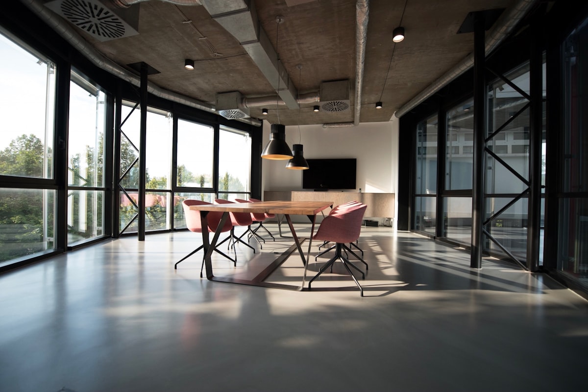 Modern office lounge with soft seating, timber finishes, and abundant daylight
