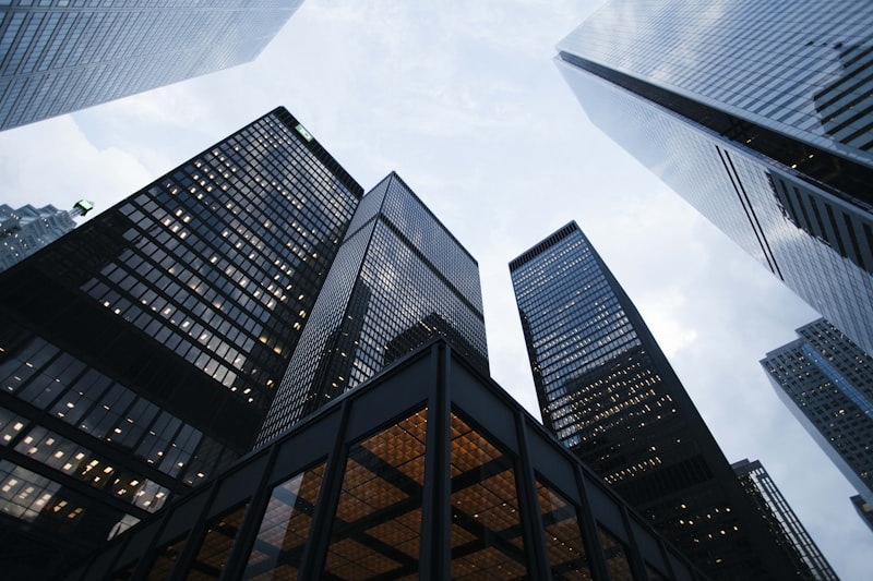 Glass skyscraper reflecting clouds against a clear sky